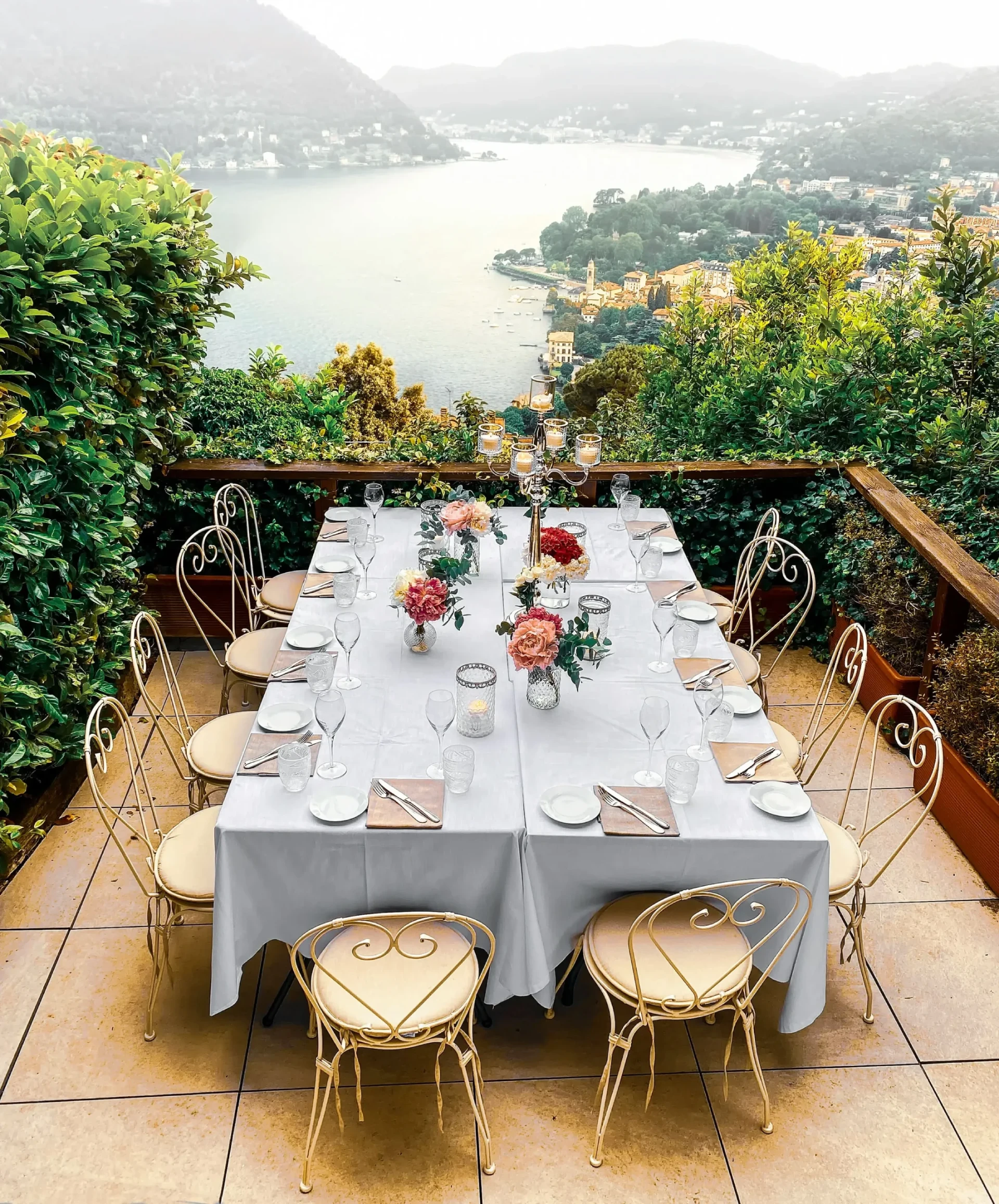 A table with chairs and a scenic lake view